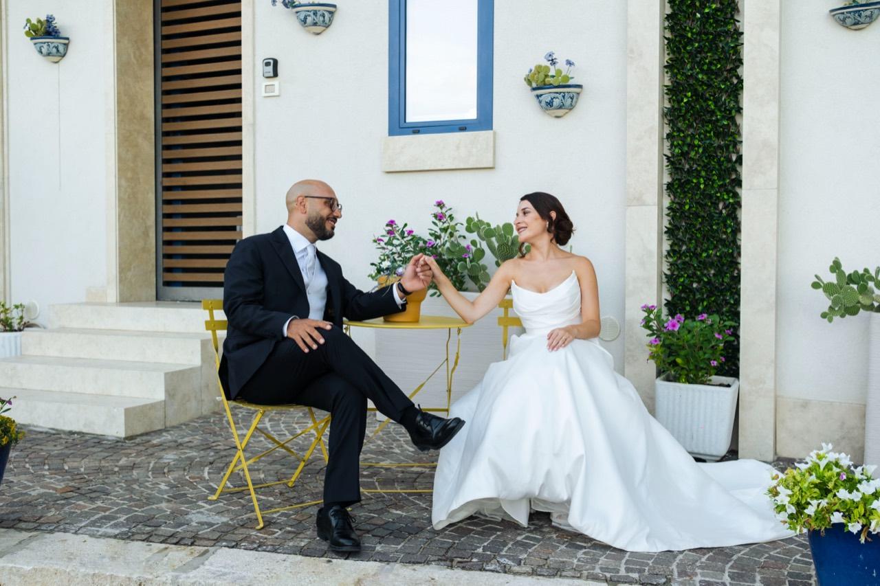 Gli sposi seduti insieme nel cortile siciliano.