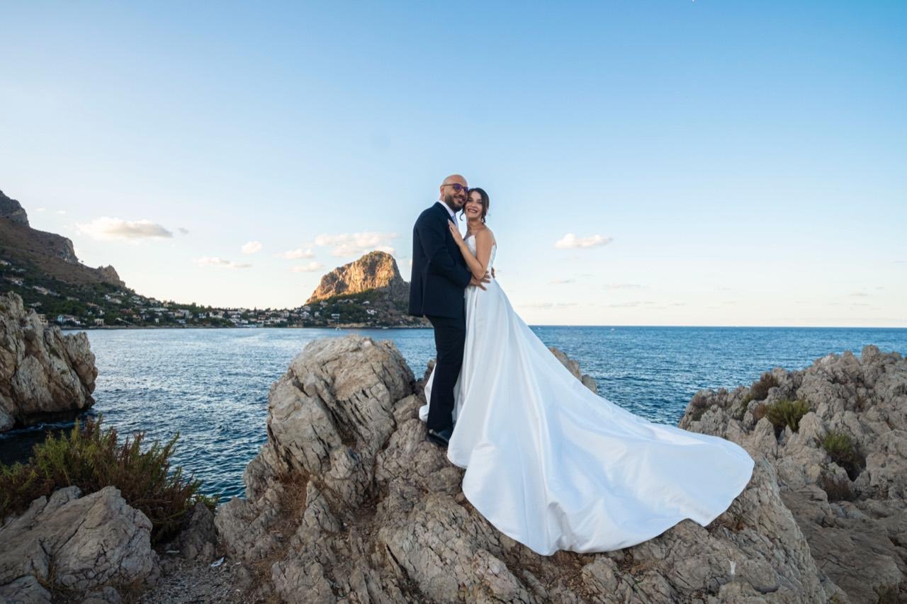 Gli sposi sulle rocce affacciate sul mare.